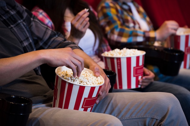 映画館でポップコーンを持つ人々