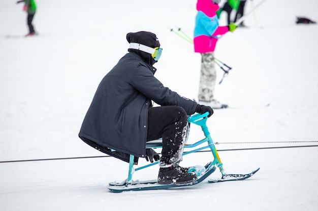 写真 バクリアニの冬の公園の雪の丘でスレッドで登っている人々