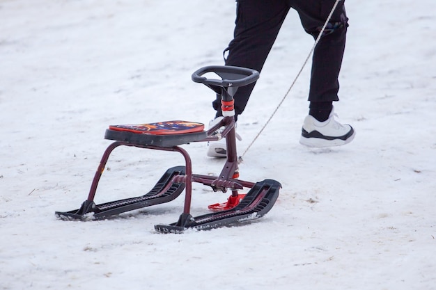 写真 バクリアニの冬の公園の雪の丘でスレッドで登っている人々