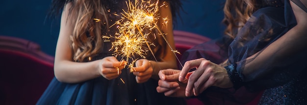 People with sparklers on Christmas background