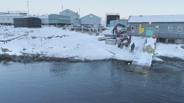Foto people work on pier of antarctic polar station vernadsky view of robotic arm