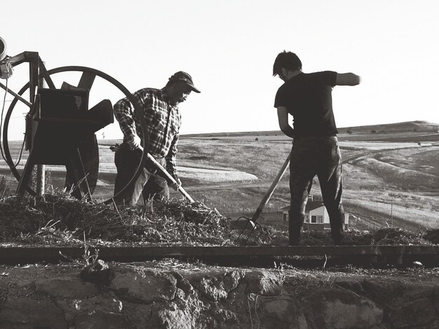 Photo people working on field against clear sky