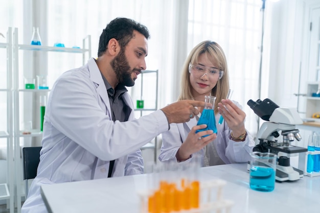 People working in the laboratory Using Magnifying Glass on Microscope