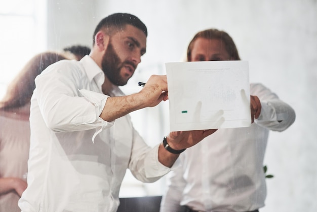 Photo people working in the office and discuss some business details using information on paper