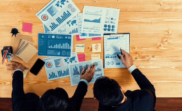 People working on a table with papers and graphs