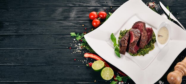 Peper Steak van kalfsvlees met spinazie Op een houten ondergrond Bovenaanzicht Kopieer de ruimte