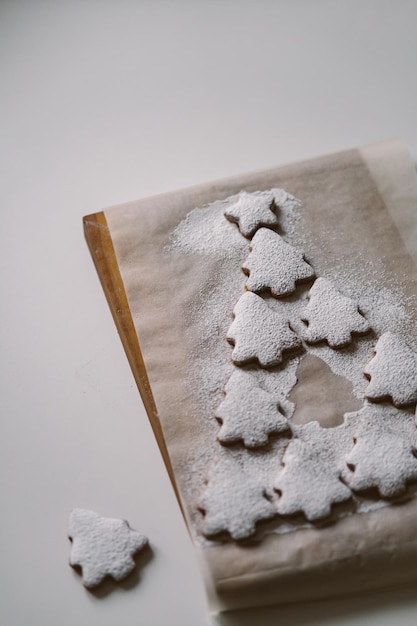 Peperkoek kerstboom bestrooid met poedersuiker op perkament