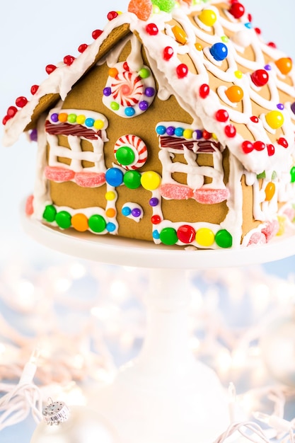 Peperkoekhuis versierd met witte royal icing en heldere snoepjes.