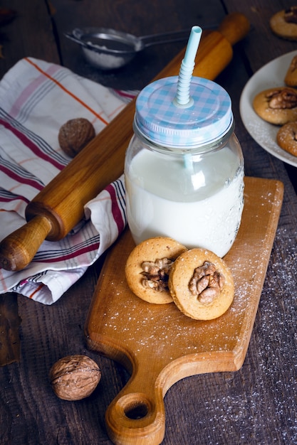 Peperkoekkoekjes met walnoten op een tafel en een kopje melk