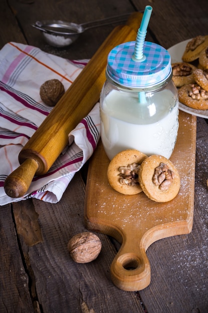 Peperkoekkoekjes met walnoten op een tafel en een kopje melk