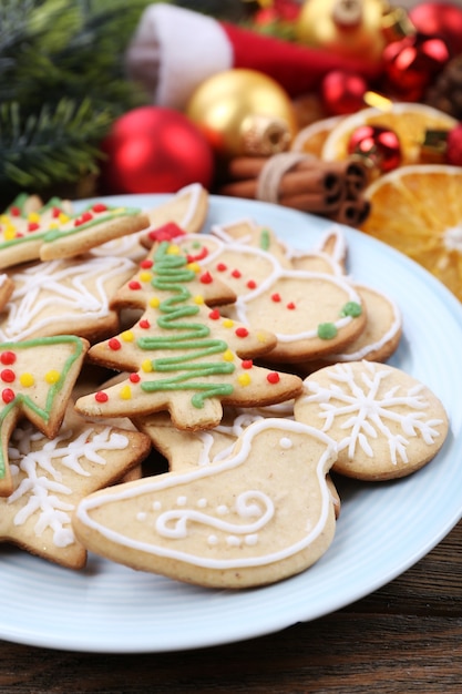 Peperkoekkoekjes op bord met kerstversiering op houten tafel