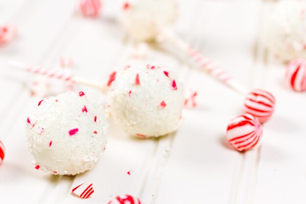 Pepermunt-chocoladecake-pops gedoopt in witte chocolade en stukjes snoepgoed.