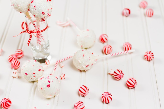 Pepermunt-chocoladecake-pops gedoopt in witte chocolade en stukjes snoepgoed.