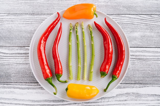 pepper and asparagus on a white table.