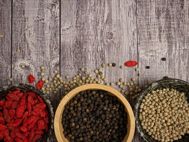 The pepper corn and goji berry on wood table for food concept