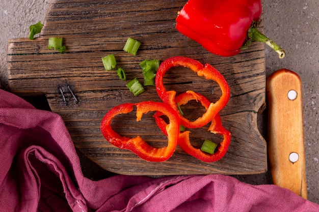 Pepper and green hand cut for salad, lie on a wooden board