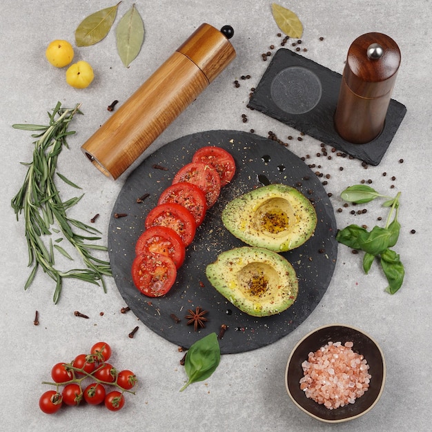 Pepper mill and salt mill on a wooden table with other products grinders on a gray stone background