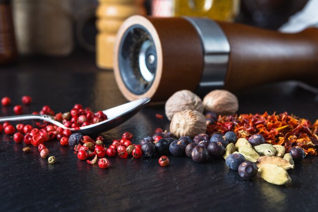 Pepper mill with pepper on a slate  surface