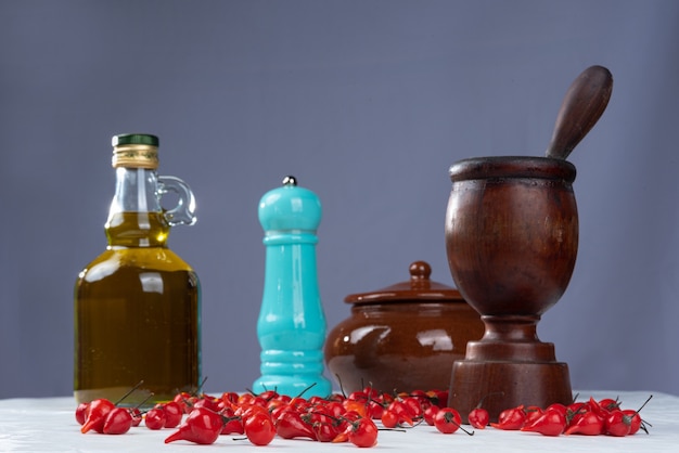 Pepper, olive oil, garlic and onion, composition with spices and accessories, with light background. Selective focus.