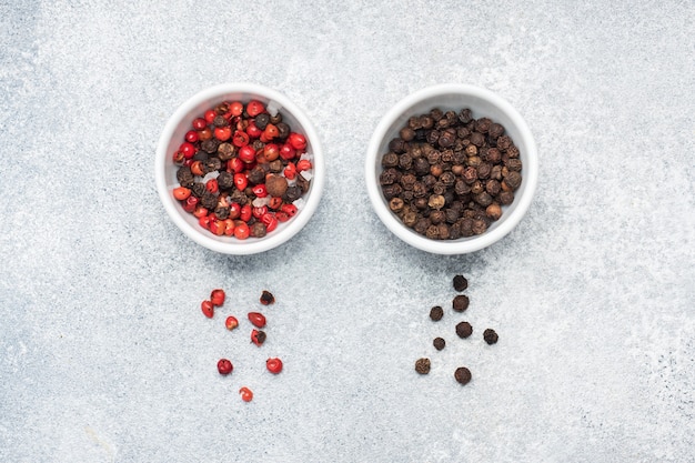 Pepper peas black and red in plates, gray concrete background, copy space.