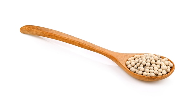 Pepper seeds in a wooden spoon on white