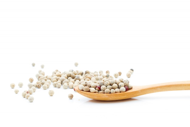 Pepper spices in a wooden spoon on a white background