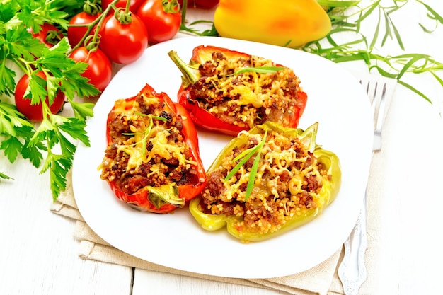 Pepper stuffed with meat and couscous in plate on light board