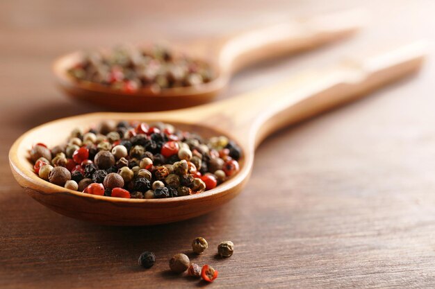 Pepper in wooden spoon on the table closeup