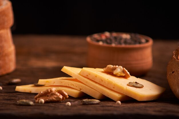 Peppercorns in a wooden bowl on table with cheese.