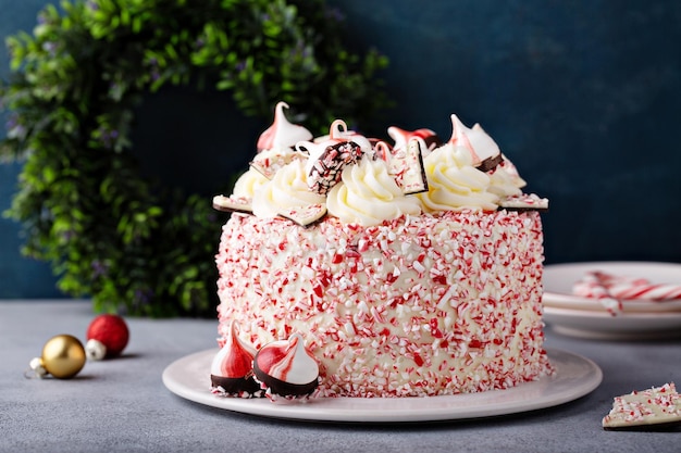 Peppermint bark and chocolate cake for Christmas on a festive background