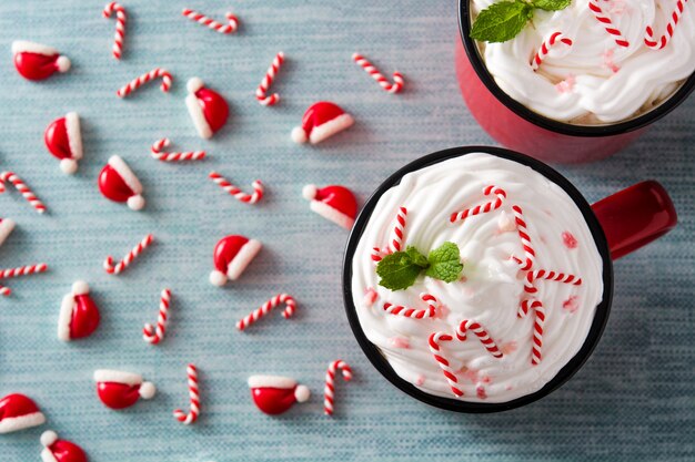 Peppermint coffee mocha decorated with candy canes for Christmas on blue  top view 