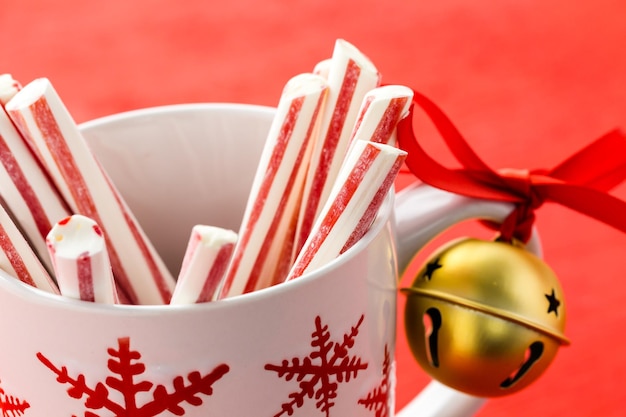 Peppermint stirrers in white cup with red snowflakes.