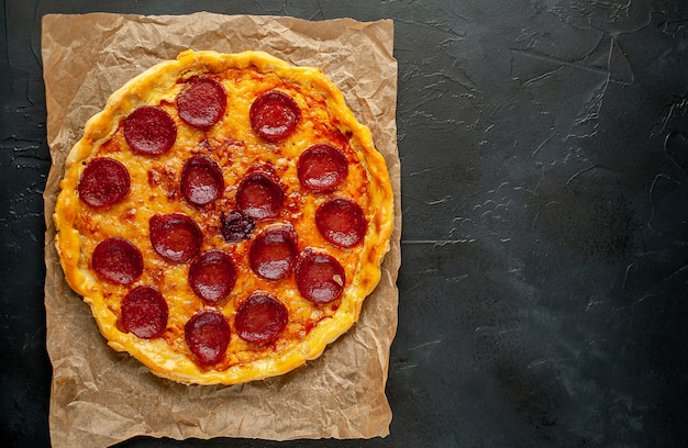 Pepperoni homemade pizza on stone background with copy space for your text.