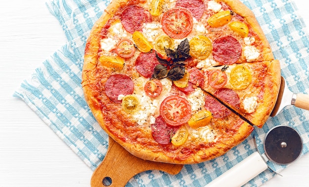 Pepperoni italian pizza with salami and cheese on rustic wooden white background