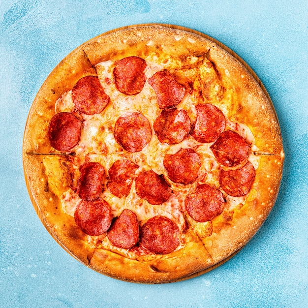 Pepperoni pizza on a blue surface