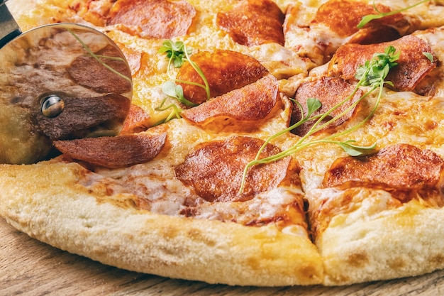 Pepperoni-pizza is een gesneden rolmes op een houten oppervlak, close-up