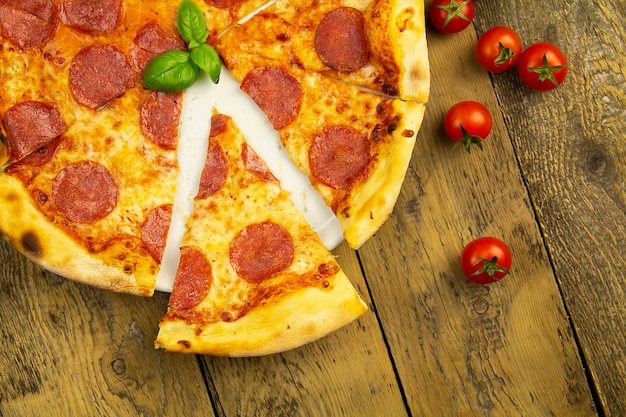 Pepperoni pizza on an old wooden table, top view