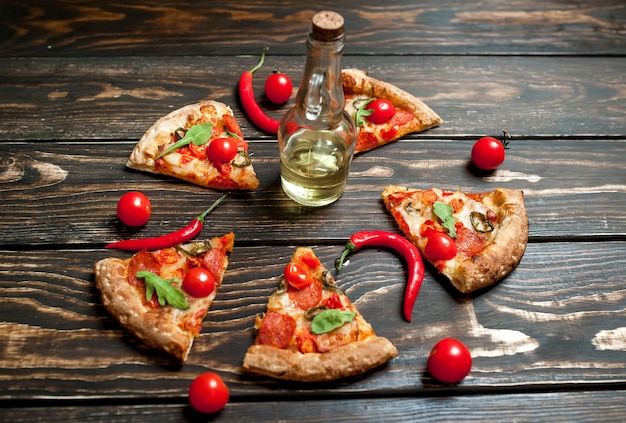 кусочки пиццы пепперони с ингредиентами на фоне дерева