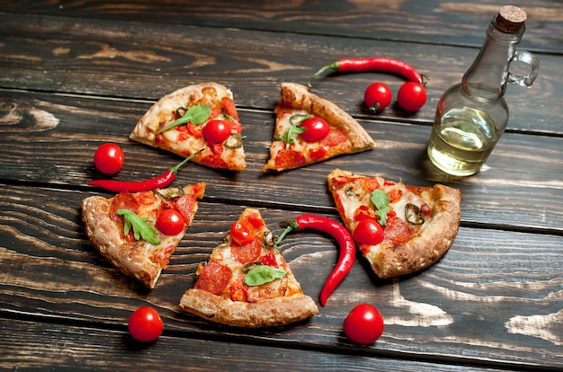 pepperoni pizza slices with ingredients on wood background