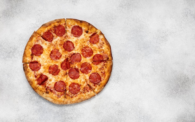 Pepperoni pizza on white concrete background. Top view with copy space.