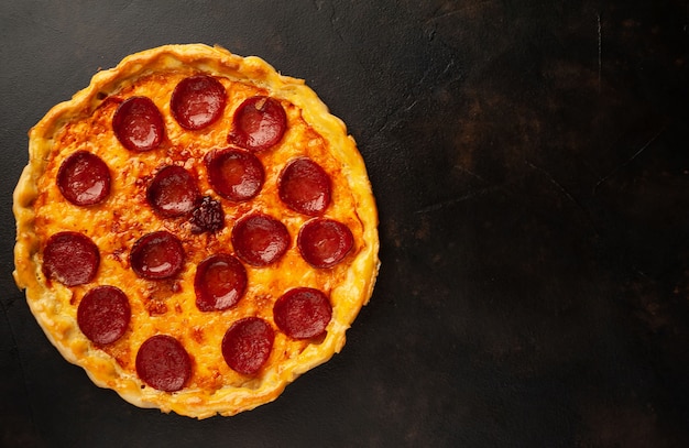 pepperoni pizza with bacon, mushrooms, olives, tomatoes on a stone background