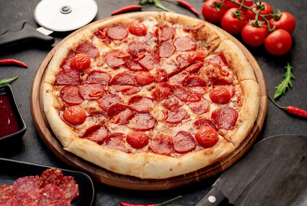 pepperoni pizza with ingredients on stone background