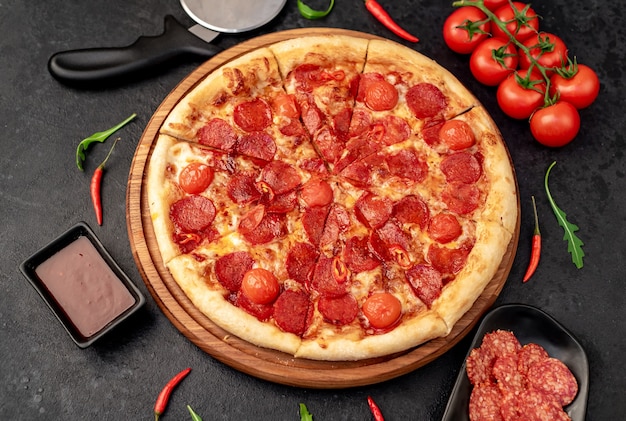 pepperoni pizza with ingredients on stone background