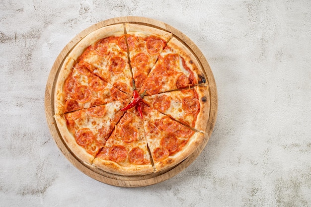 Pepperoni pizza with meat and pepper on the concrete background
