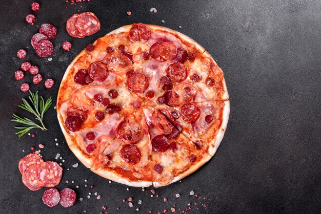 Pepperoni pizza with mozzarella cheese, salami, tomatoes, pepper and spices. Italian cuisine