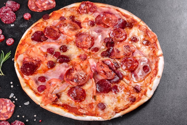 Pepperoni pizza with mozzarella cheese, salami, tomatoes, pepper and spices. Italian cuisine