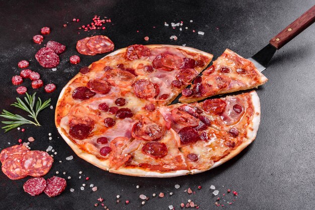 Pepperoni pizza with mozzarella cheese, salami, tomatoes, pepper and spices. Italian cuisine