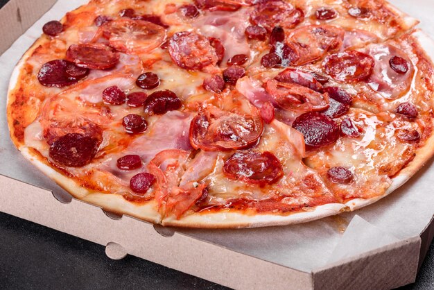 Pepperoni pizza with mozzarella cheese, salami, tomatoes, pepper and spices. Italian cuisine