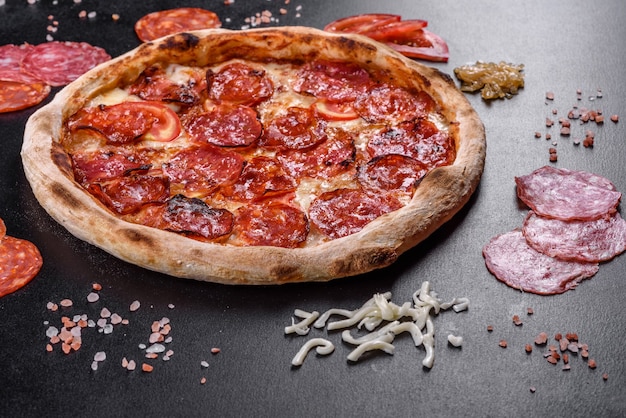 Пицца пепперони с соусом для пиццы, сыром моцарелла и пепперони. Пицца на столе с ингредиентами