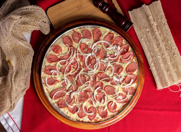 나무 배경의 페퍼로니 피자 피자 데 칼라브레사(pizza de calabresa) 평면도라고 불리는 브라질 피자